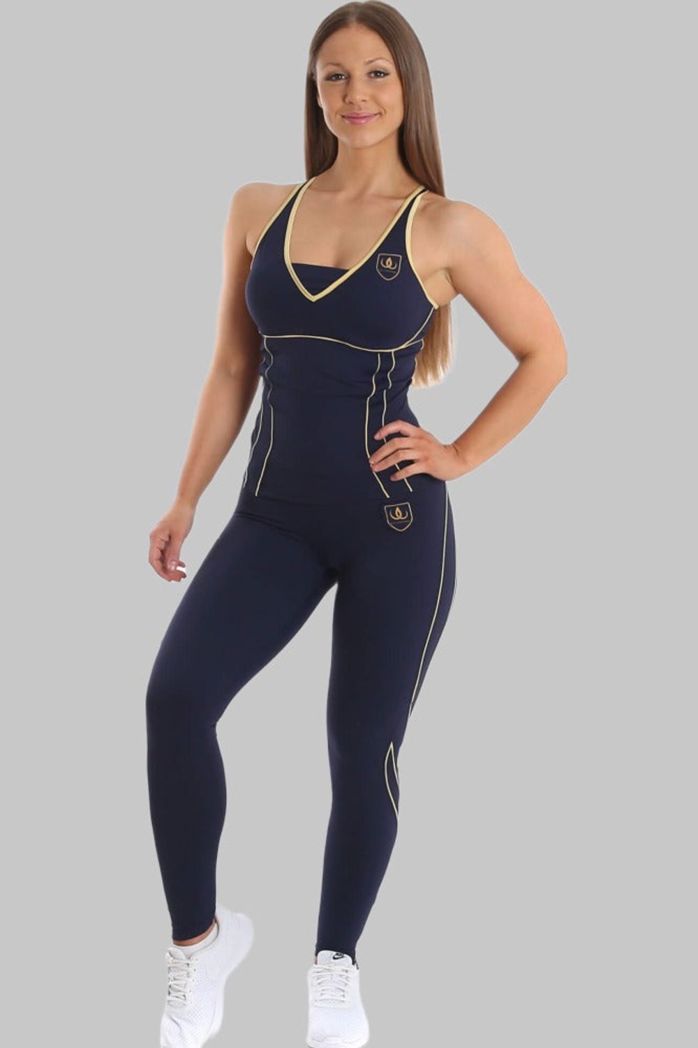 Modellen står i marinblått linne och marinblå tights med guldlinjer, till vita sneakers.