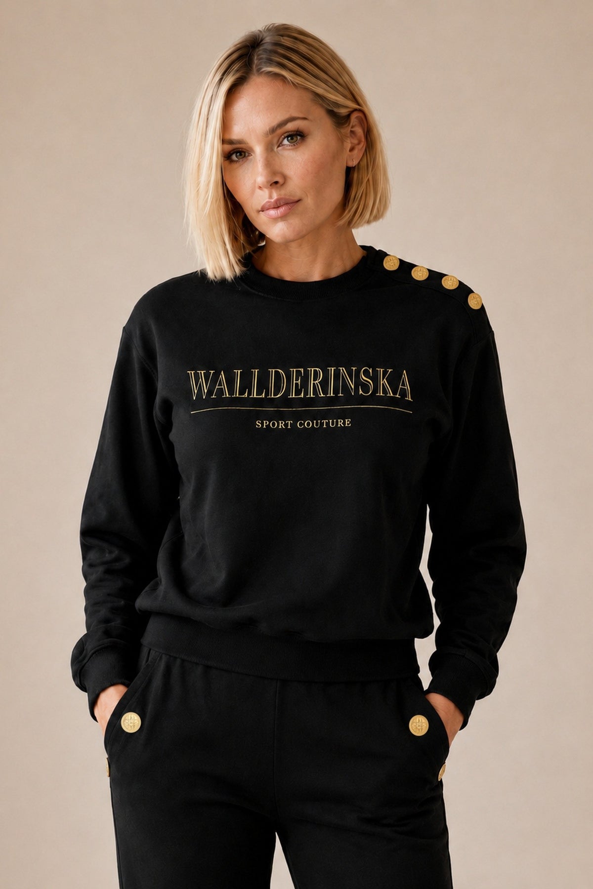 Edge Gold Button Sweater och Pants i svart i studio, med fyra guldknappar på axeln och en vid varje ficka.